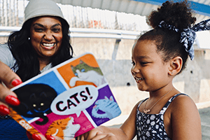 A photo of a mother showing her daughter a literacy kit from the United Way.